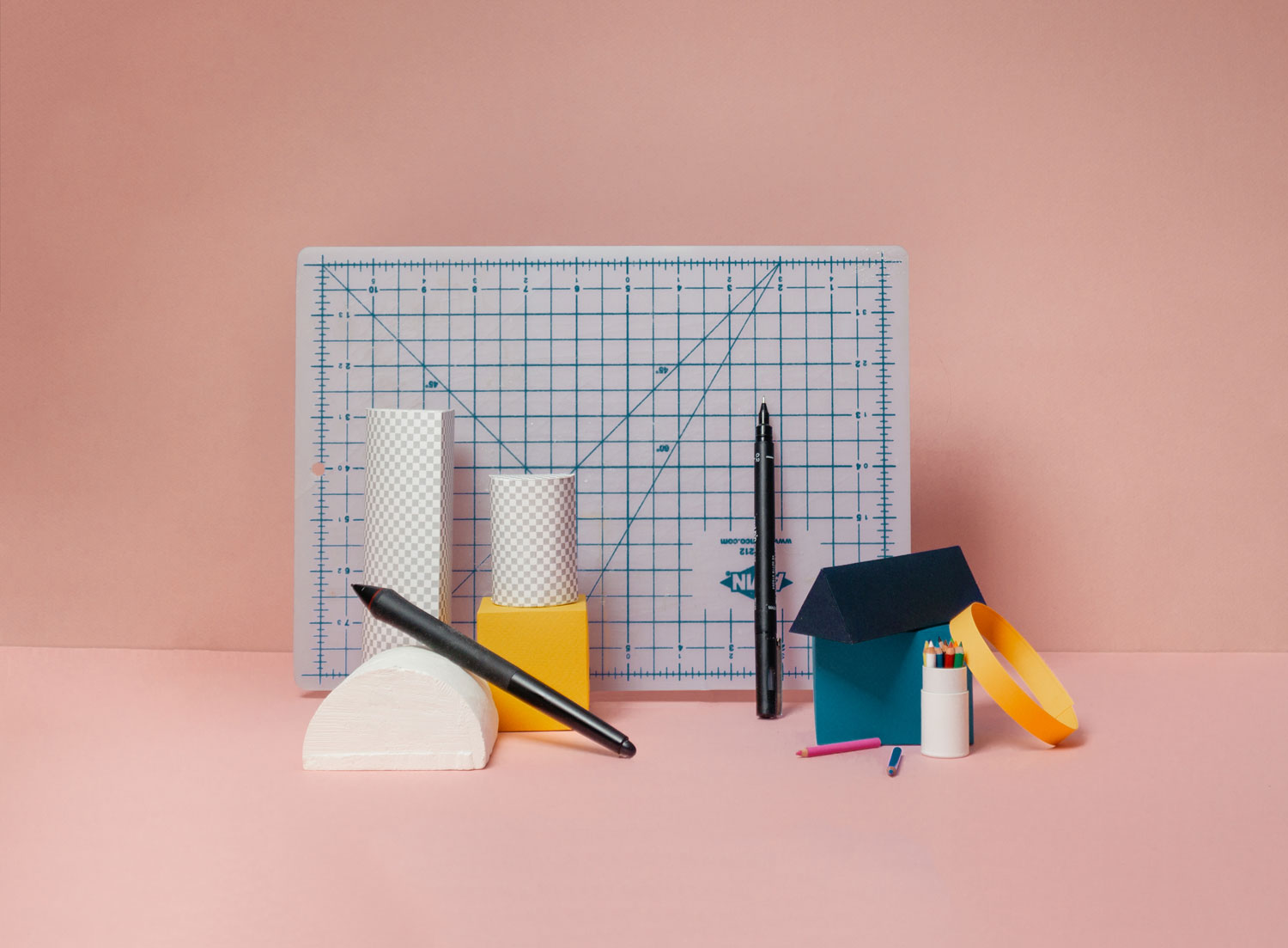 Maths board with a collection of blocks of different shapes, pens, and pencils arranged in front.