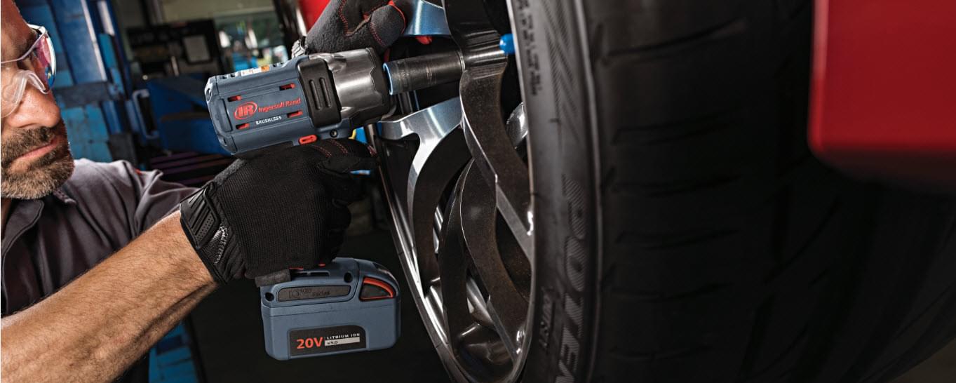 Man holding power tool working on an automobile